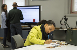 Photograph of Kristalynn Williams contributing archival items for scanning at Modern School multigenerational reunion
