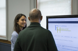 Photograph of Teachers College student Esther Cyna presenting digital collection site to Modern School multigenerational reunion participant